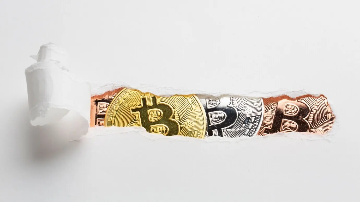 Papel desgarrado que deja al descubierto bitcoin